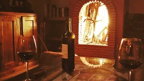 A table with a bottle of wine, two glasses, and a magazine.