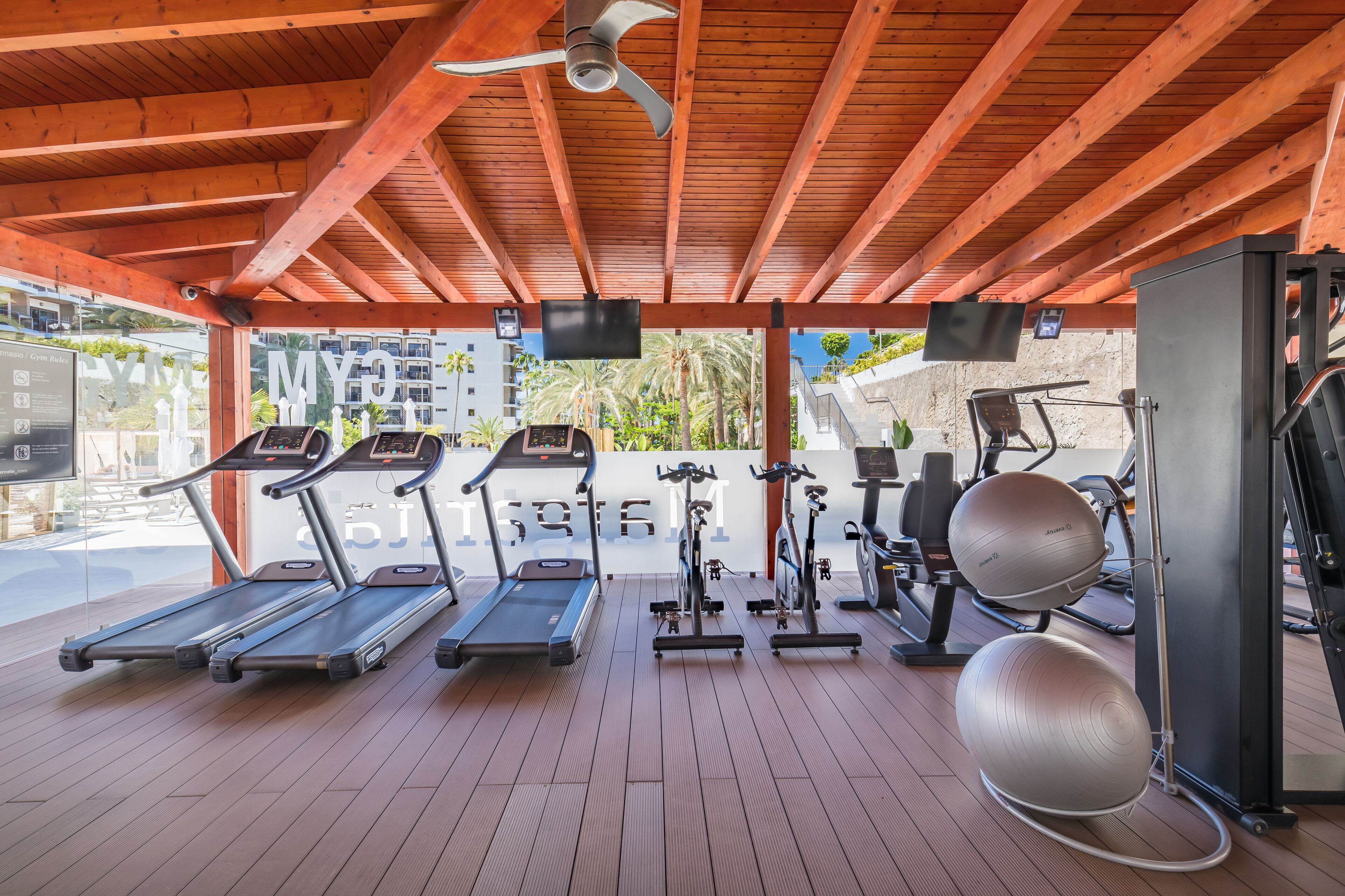 Un espace de remise en forme extérieur abrité, équipé de tapis de course, d’appareils elliptiques et de ballons d’exercice.
