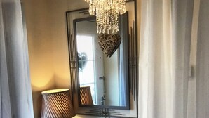A hallway with a mirror, a lamp, and a decorative heart hanging on the wall. - Lazy Nest - Sleeps 4, Parking, Garden & Hammocks (Oakham)