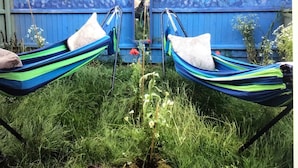 Two hammocks tied to a blue structure with a mural of fish. - Lazy Nest - Sleeps 4, Parking, Garden & Hammocks (Oakham)