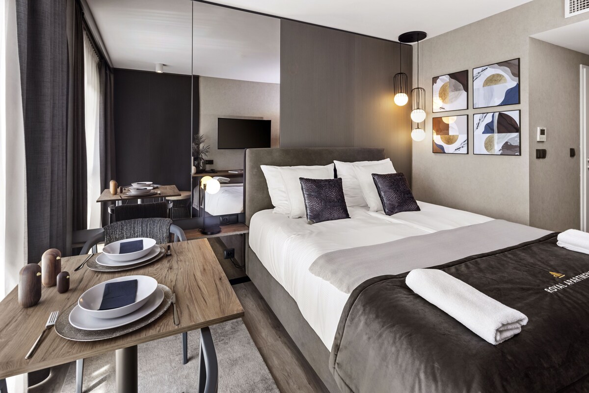 Ein Hotelzimmer mit Bett, Nachttisch und Schreibtisch mit Stuhl.