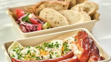 A tray with sliced bread and a dish containing eggs and bacon.