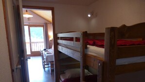 A bunk bed room with a table and chairs in the background. - 2-room apartment, 4 people, Méribel center, close to shops & slopes (Méribel)