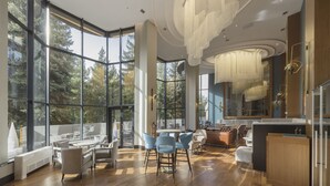 Een ruim, modern interieur met grote ramen, een centrale zithoek en een keuken.