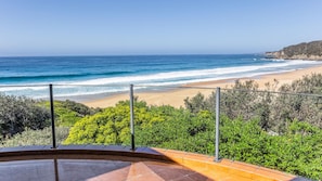 A beach view from a balcony with a railing, ocean, and vegetation. - Bermi Bliss - Dickinson Avenue 7 (Bermagui)