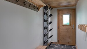 A hallway with a wooden bench, a coat rack, and a door with a window. - Family Apartment in Peaceful Area, Close to Slopes (Méribel)