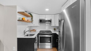 Una cucina moderna con mobili bianchi, elettrodomestici in acciaio inossidabile e forno integrato.