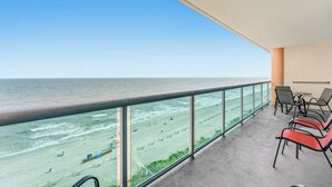Ein Balkon mit Blick auf Strand und Meer.