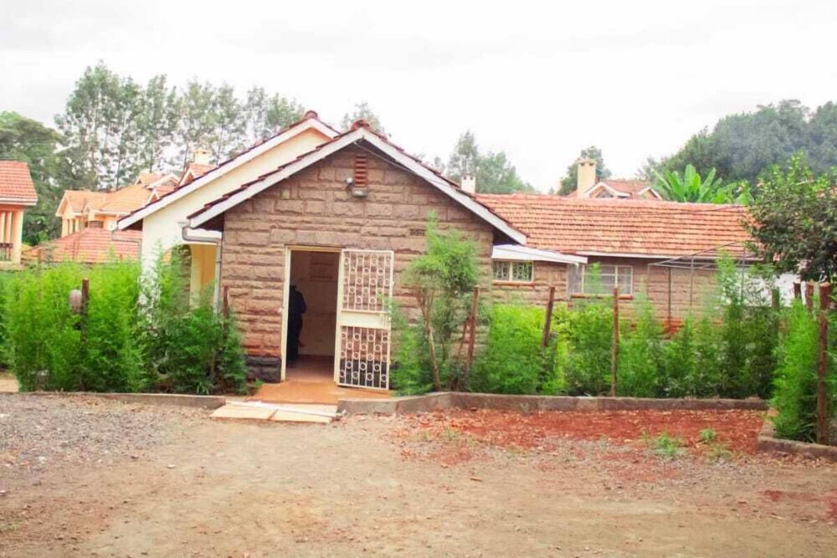 Un bâtiment rustique en pierre, doté d’une porte en bois et d’un petit porche.