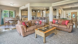 Ein geräumiges Wohnzimmer mit zwei Ledersofas, einem Couchtisch und einem Essbereich mit Stühlen und einem Tisch.