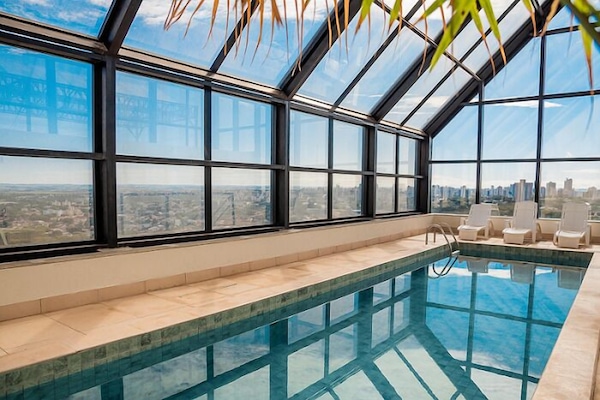 Una piscina techada, sillones reclinables de piscina