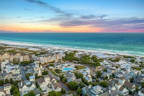 A coastal residential area with beachfront properties, a swimming pool, and a clear view of the ocean.