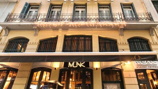 La façade d’un hôtel, ornée d’une grande enseigne « MUNK », de nombreux balcons et de grandes fenêtres.