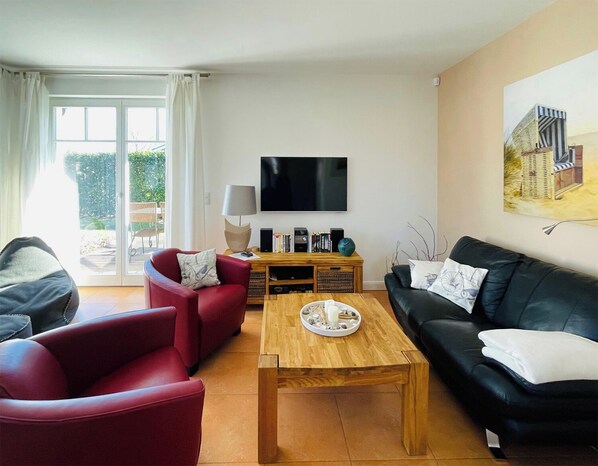 Relax in style with a flat-screen TV, comfortable sofas, and a sliding door to the outdoors.