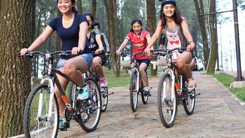 A group of people riding bicycles on a paved path in a park.