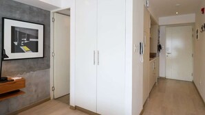 A hallway with a white wardrobe, a framed picture on the wall, and a wooden shelf. - w*| Spacious Loft w/AC in Barranco (Barranco)