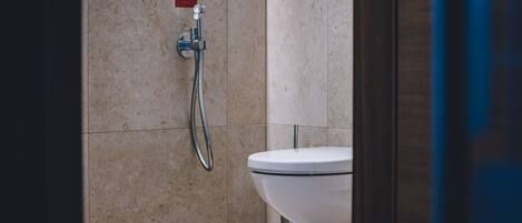 A bathroom with a shower, toilet, and a sign on the wall.