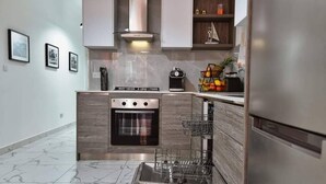 A modern kitchen with a built-in oven, a dishwasher, and a coffee maker. - A Bed of Roses (Żebbuġ)