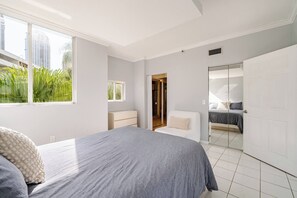 A bedroom with a bed, a dresser, a chair, and a closet. - Le Montcalm 102 STR-03618 (Sunny Isles Beach)