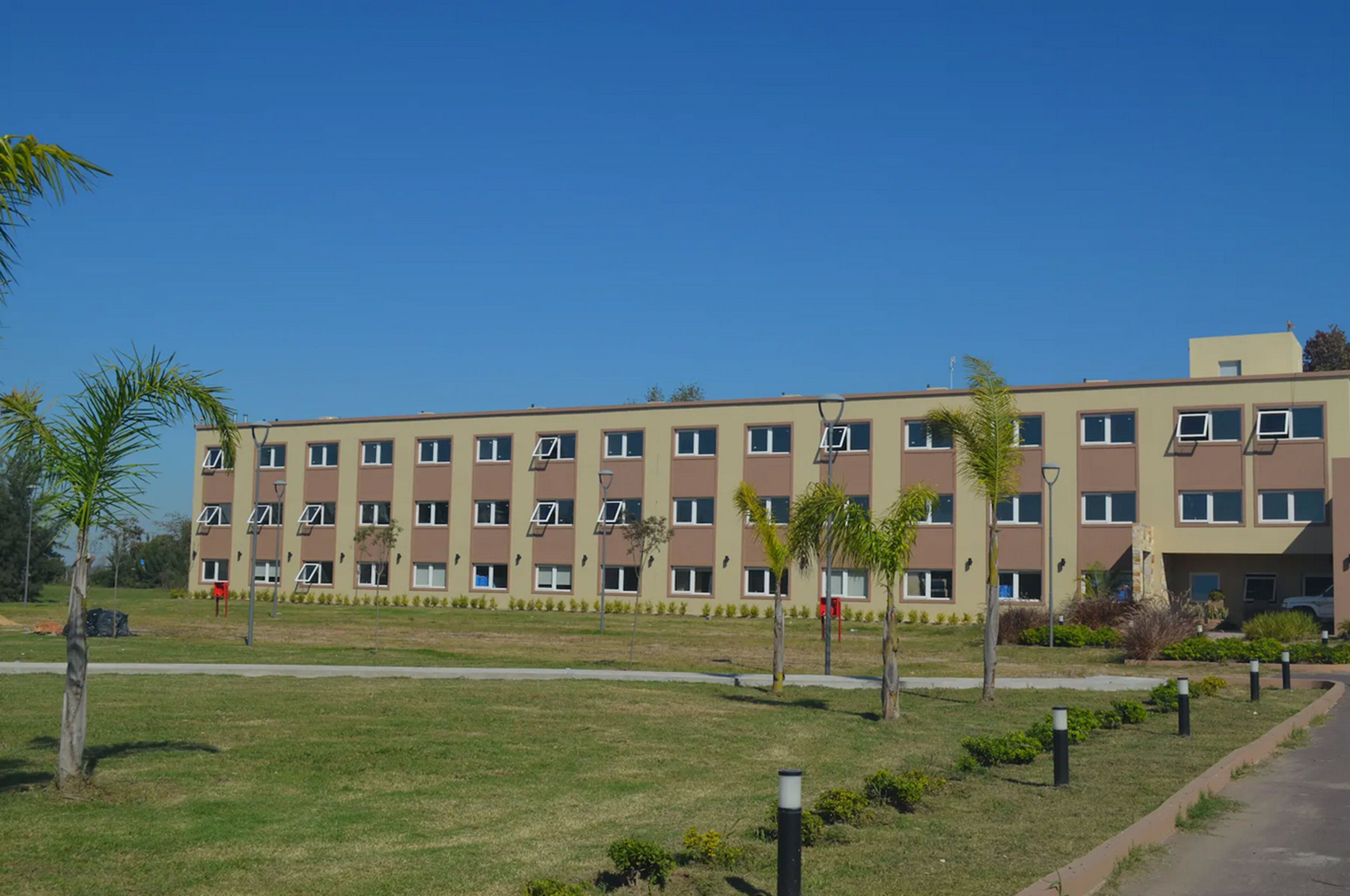 Un edificio de varios pisos con techo plano, ventanas rectangulares y fachada uniforme.
