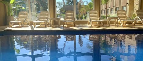 Piscine couverte, piscine extérieure, parasols de plage, chaises longues