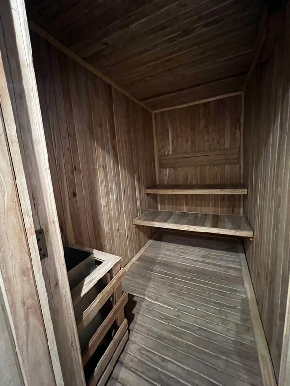 A wooden interior with a sloped ceiling, a built-in bench, and a shelf. - Days Inn by Wyndham Zarate (Zárate)