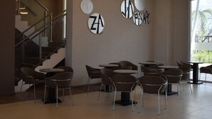 A modern interior with a staircase, circular ceiling lights, and seating areas. - Days Inn by Wyndham Zarate (Zárate)
