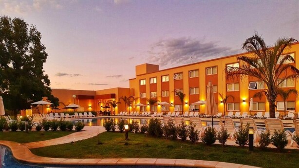 A hotel with a swimming pool, sun loungers, and a well-lit outdoor area. - Days Inn by Wyndham Zarate (Zárate)