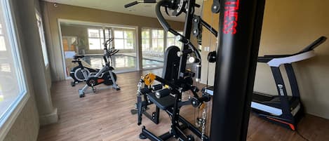 A gym with cardio machines, weightlifting equipment, and a punching bag.