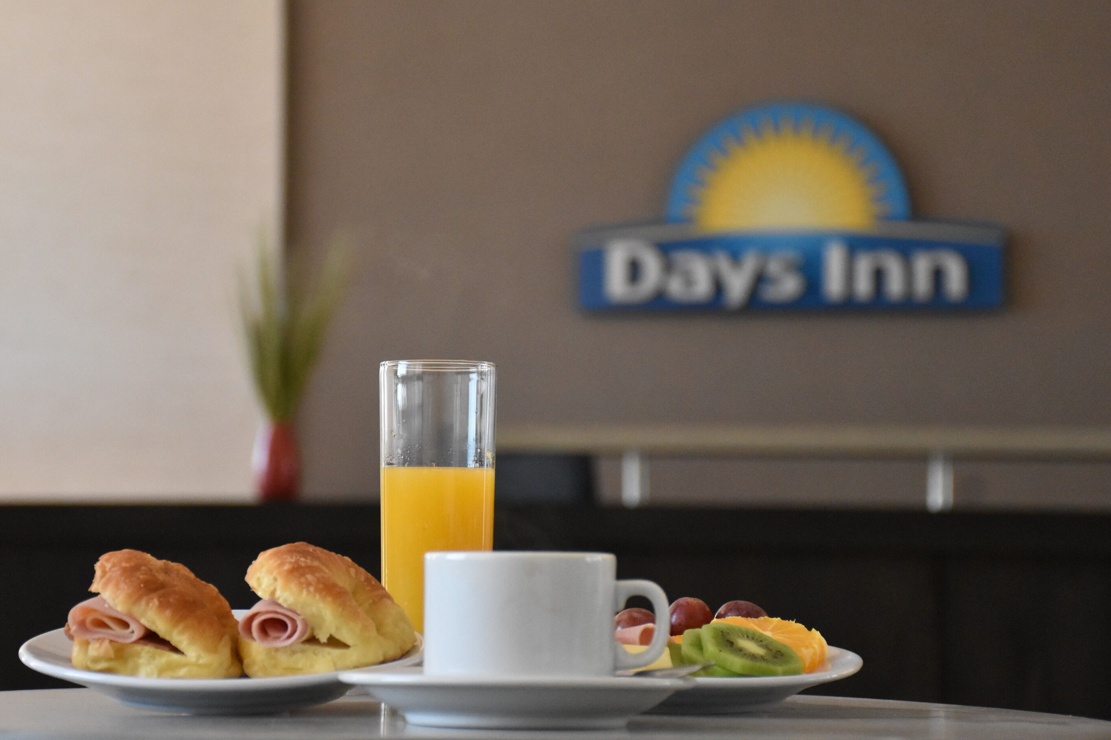Desayuno con pasteles, fruta y zumo de naranja en Days Inn.