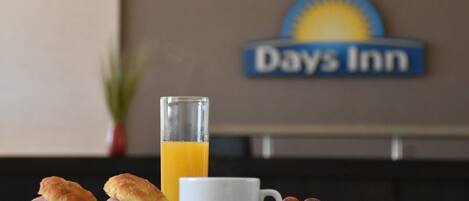 Desayuno con pasteles, fruta y zumo de naranja en Days Inn.