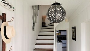 A staircase with white walls and wooden steps leading to a kitchen area.