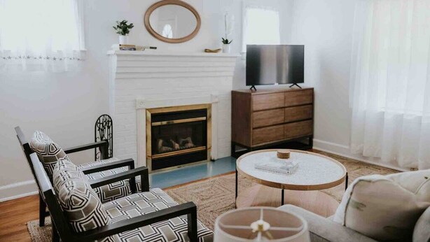 Ein Wohnzimmer mit Kamin, Fernseher, Sofa und Couchtisch.