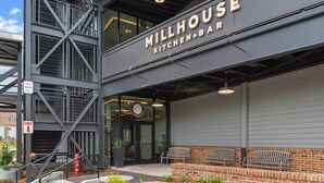 A modern building with a sign reading "Millhouse Kitchen+Bar".