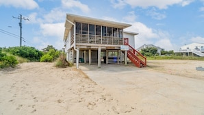 A two-story building with a balcony and a red staircase. - Book Shifting Sands | Sandbridge Beach Vacation Rental (Virginia Beach)