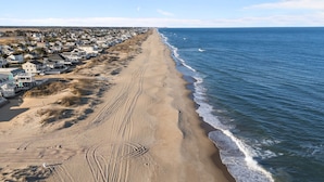 A coastal residential area with houses along the beach and a sandy path leading to the water. - Book Shifting Sands | Sandbridge Beach Vacation Rental (Virginia Beach)