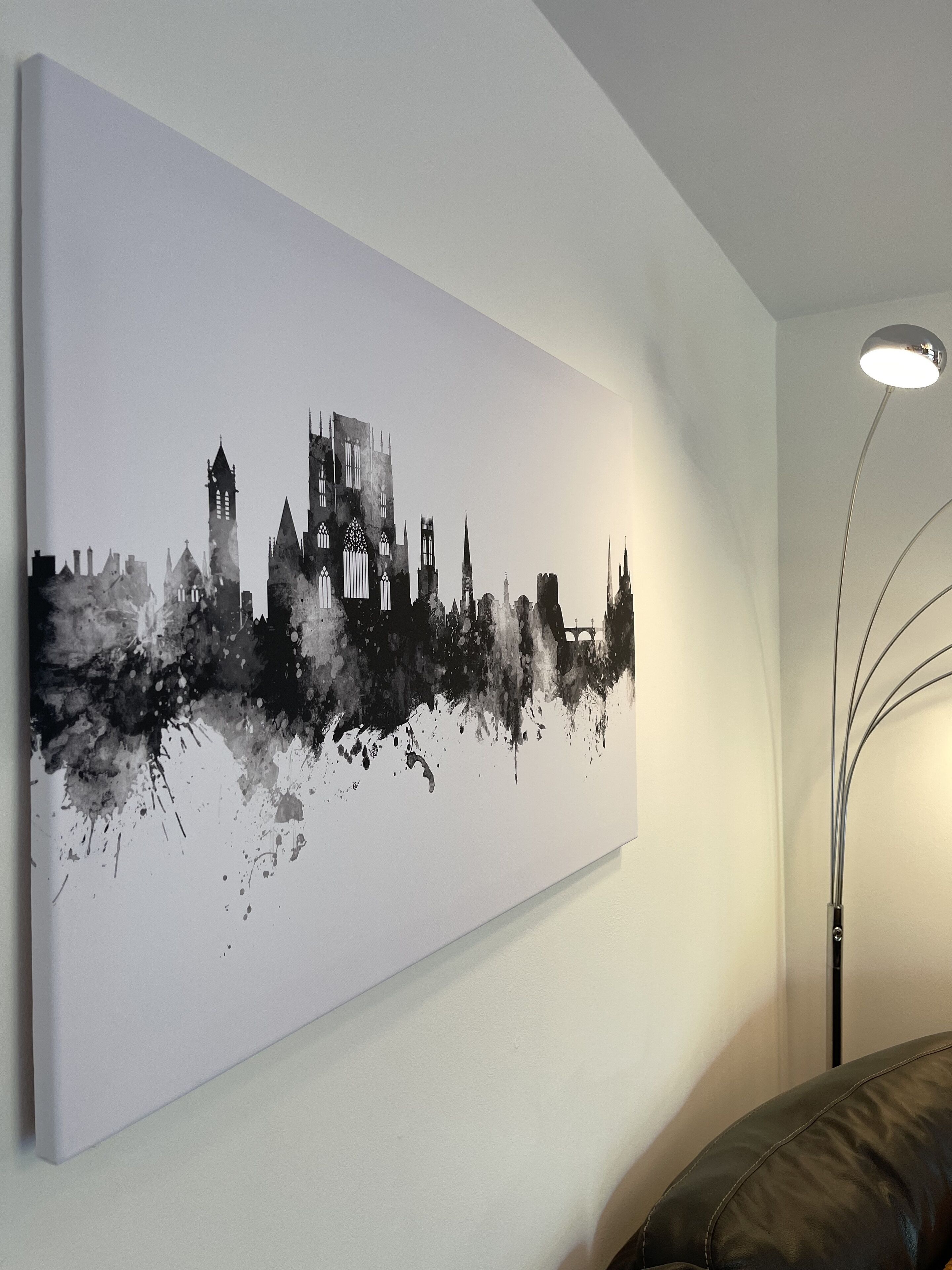 A large black and white cityscape painting on a wall.