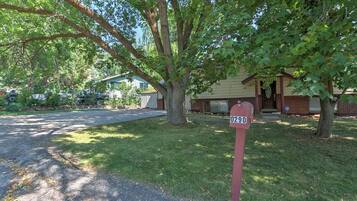A residential area with a mailbox labeled 0290, a house with a brick facade, and a driveway leading to the house.