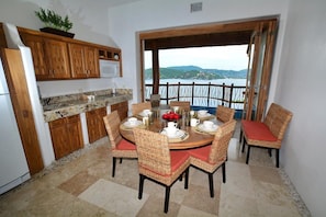 Enjoy meals with family and friends at this dining area, featuring a round table and wicker chairs.