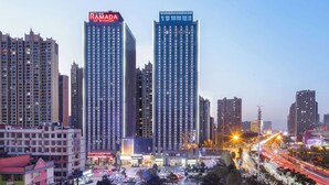 Un paisaje urbano con dos edificios altos destacados, uno con un letrero que dice "RAMADA BY WYNDHAM".