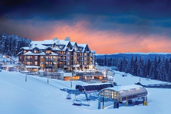 A large lodge with multiple floors, ski lifts, and a covered area for equipment.