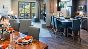 Et moderne hotelværelse med spiseplads, tekøkken og en balkon med en smuk udsigt.