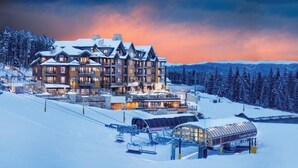 En stor lodge med flere etager, skilifte og et overdækket område til udstyr.