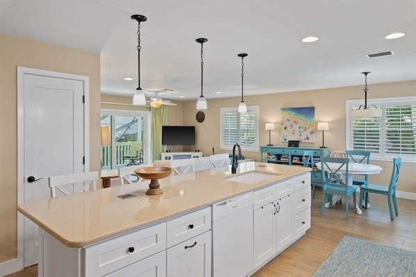 A kitchen with a large island, white cabinets, and pendant lighting. - Welcome to "Little Sanibel" 2/2 with Pool on East End Sanibel (Sanibel)