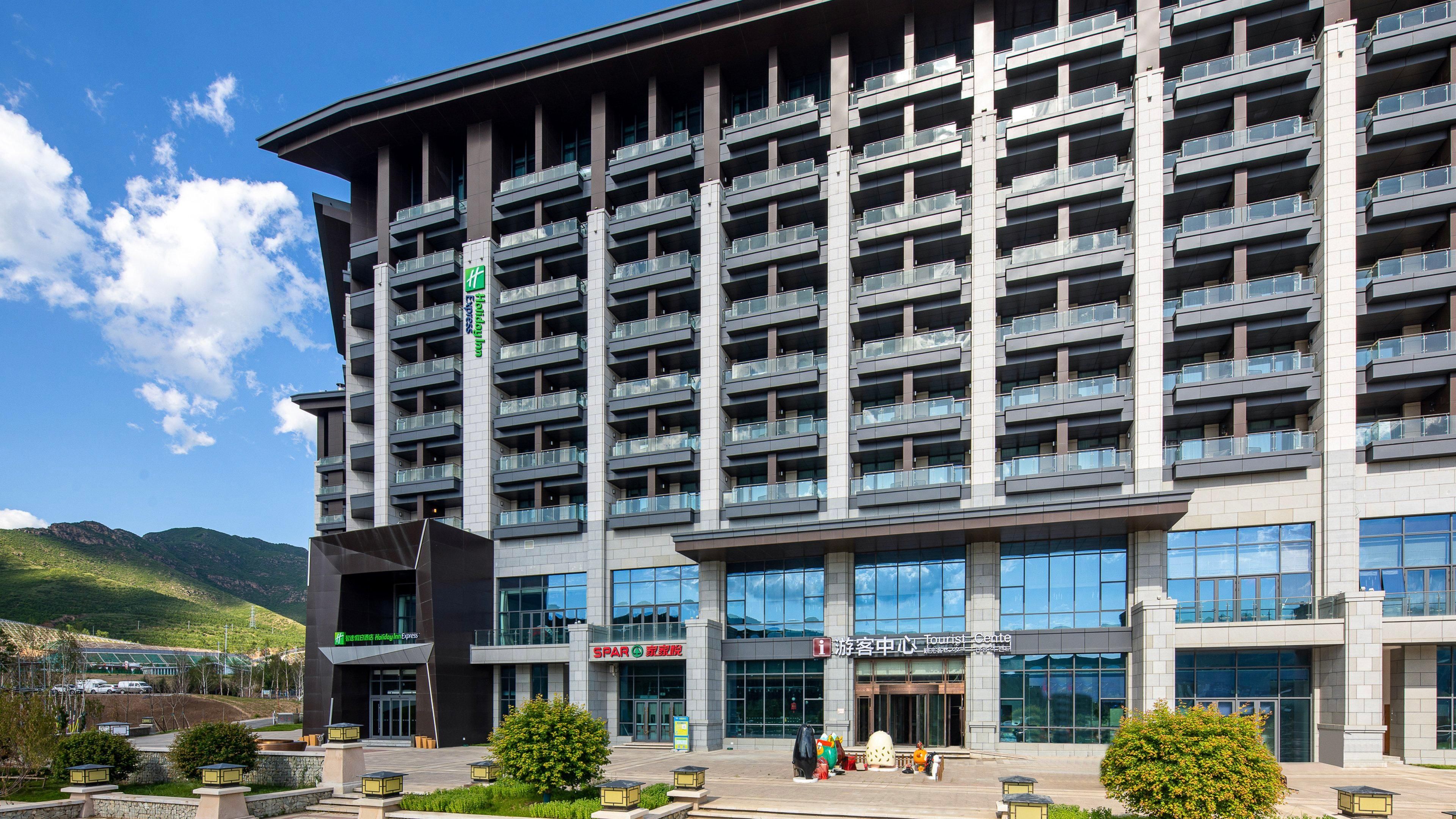 A multi-story hotel with balconies, a Holiday Inn Express sign, and a Tourist Centre.