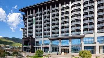 Un hotel de varios pisos con balcones, un letrero de Holiday Inn Express y un Centro de Turismo.