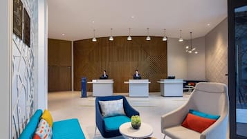A modern lobby with reception desks, seating areas, and pendant lighting.