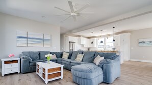 A spacious living room with a grey sectional sofa, a white coffee table, and a ceiling fan. - SeaBreeze  (Surf City)