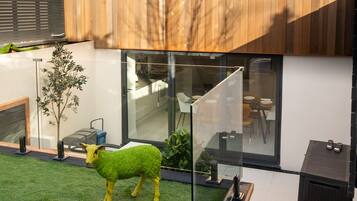 Enjoy outdoor dining or relaxation in the beautifully landscaped garden with a decorative sculpture and seating area.