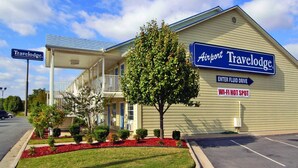 A Travelodge hotel with a covered entrance, a sign indicating a Wi-Fi hot spot, and a direction sign for the Airport Fluid Drive.